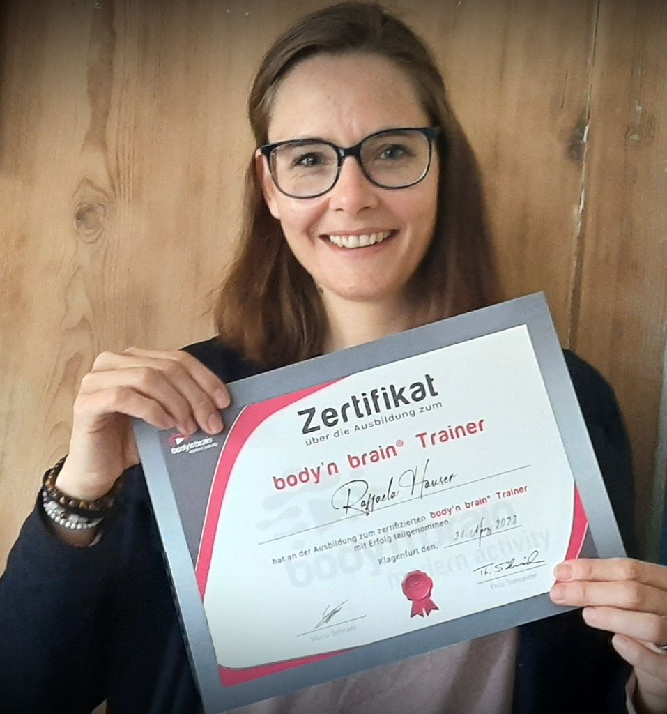 Raffaela Hauser, body’n brain Trainerin in Winterthur, Schweiz, zeigt ihr Zertifikat für die erfolgreich absolvierte body’n brain Trainer-Ausbildung.